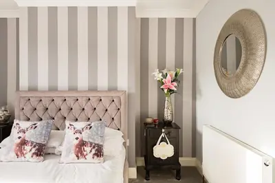 a bedroom with a bed with two pillows and a mirror at A Wave From It All in Great Clacton