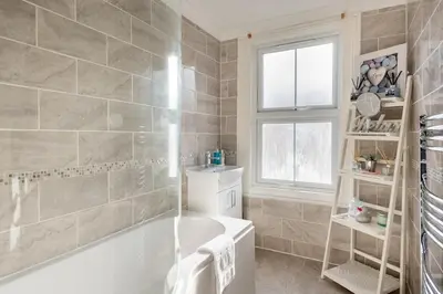 a bathroom with a bath tub and a window at A Wave From It All in Great Clacton