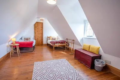 a attic room with a couch and a table at Heart's Ease in Dallinghoo nr Woodbridge in Woodbridge
