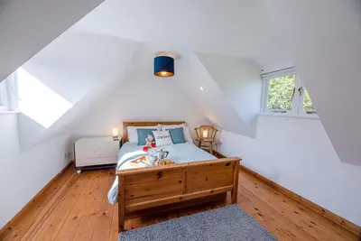 a bedroom with a bed with a wooden floor at Heart's Ease in Dallinghoo nr Woodbridge in Woodbridge