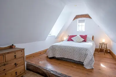 a bedroom with a bed and a wooden floor at Heart's Ease in Dallinghoo nr Woodbridge in Woodbridge