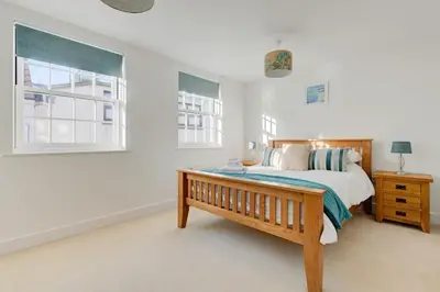 a bedroom with a wooden bed and a window at Juniper House in Harwich