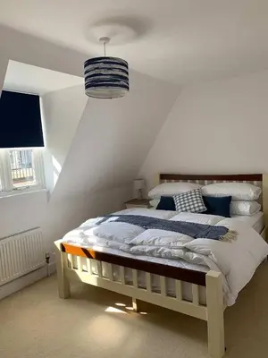 a white bedroom with a large bed in a room at Juniper House in Harwich