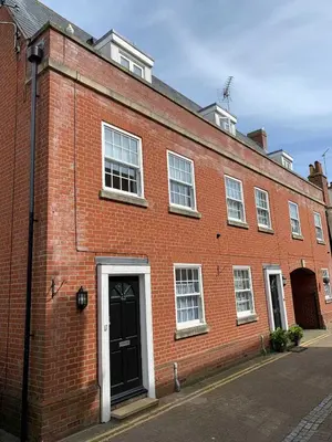 a large red brick building with a black door at Juniper House in Harwich