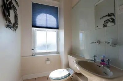 a bathroom with a sink and a toilet and a window at The Lookout Penthouse in Harwich