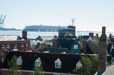 a city with houses and a ship in the water at The Lookout Penthouse in Harwich