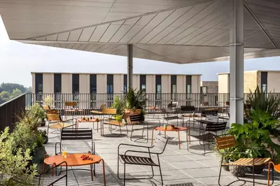 a patio with tables and chairs on a roof at Hyatt Centric Cambridge in Cambridge