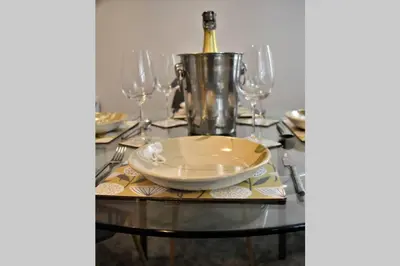 a table with a plate and wine glasses on it at The Alvaros Apartment in Southend-on-Sea