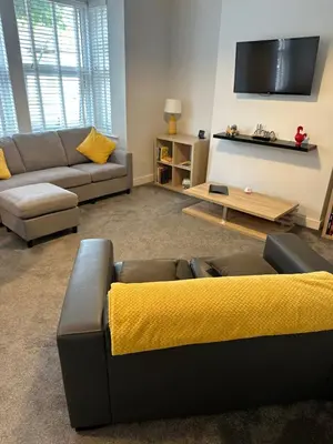 a living room with a couch and a flat screen tv at The Alvaros Apartment in Southend-on-Sea