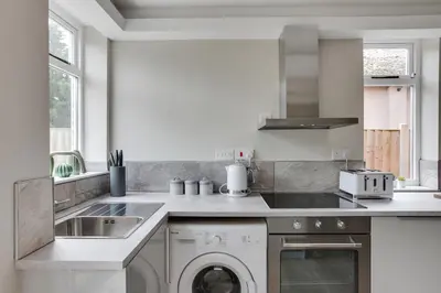 a kitchen with a washing machine and a sink at Spacious Three Bedroom House - Free Parking & Wifi in Chelmsford