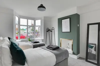 a bedroom with two beds and a mirror at Spacious Three Bedroom House - Free Parking & Wifi in Chelmsford