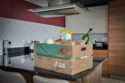 a box of food and a bottle of wine on a counter at The Marina Penthouse in Ipswich