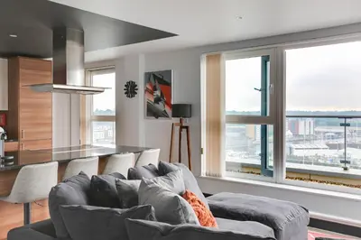 a living room with a couch and large windows at The Marina Penthouse in Ipswich