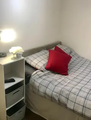 a bed with a red pillow on top of it at 2 Bedroom 2 Double beds Kitchen 2Baths Parking in Bishops Stortford