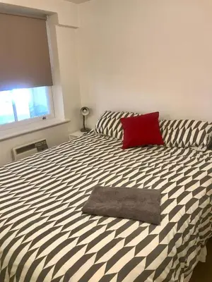 a bedroom with a bed with a red pillow on it at 2 Bedroom 2 Double beds Kitchen 2Baths Parking in Bishops Stortford