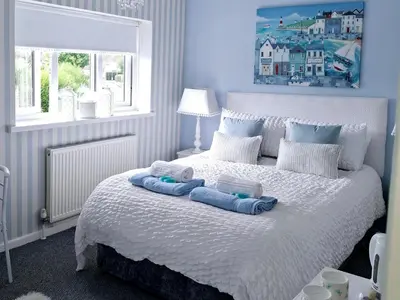 a bedroom with a bed with two towels on it at HOME from HOME GUEST HOUSE in Rochford