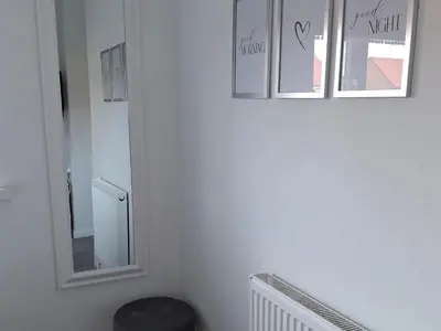 a white room with three mirrors and a stool at HOME from HOME GUEST HOUSE in Rochford