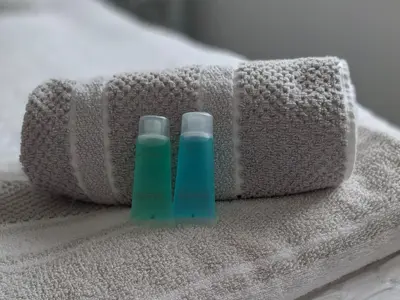 two bottles ofodorizers sitting on top of a towel at HOME from HOME GUEST HOUSE in Rochford