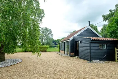 a small house with a gravel driveway next to it at The Half House in Snape