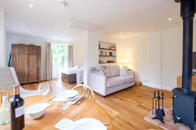 a living room with a couch and a table with wine glasses at The Half House in Snape