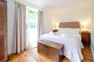 a bedroom with a bed and a large window at The Half House in Snape