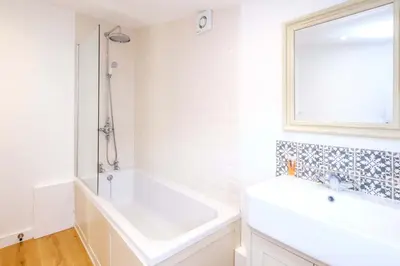 a white bathroom with a tub and a sink at The Half House in Snape
