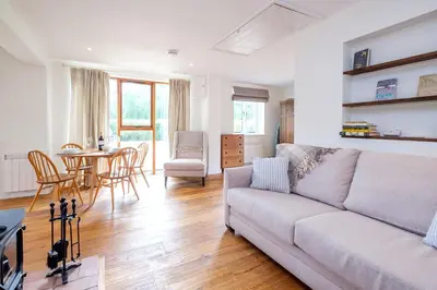 a living room with a couch and a table and chairs at The Half House in Snape