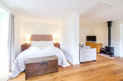 a bedroom with a bed with a wooden table in it at The Half House in Snape
