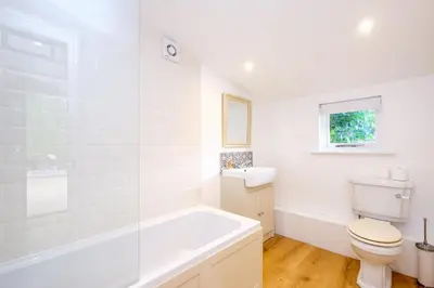 a bathroom with a tub and a toilet and a sink at The Half House in Snape