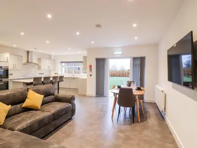 a living room and kitchen with a couch and a table at Exning Residence in Newmarket