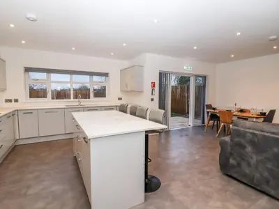 an open kitchen and living room with a table at Exning Residence in Newmarket