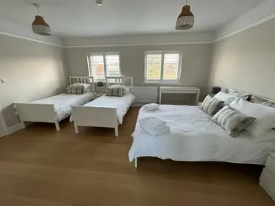 a bedroom with two beds and two windows at Magnolia House in Royston