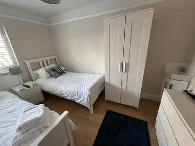 a small bedroom with two beds and a closet at Magnolia House in Royston