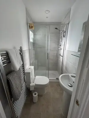 a bathroom with a shower and a toilet and a sink at Magnolia House in Royston
