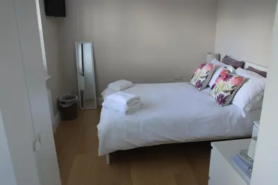 a white bed with pillows and towels on it at Magnolia House in Royston
