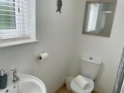 a white bathroom with a toilet and a sink at Number 15 in Norwich