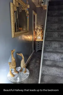 a hallway that leads up to the basement with two figurines at Quaint & Quirky House Colchester Town Centre in Colchester