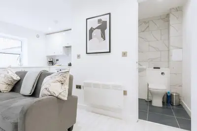 a white living room with a couch and a toilet at Budget 1 Bedroom Apartment in Central Ipswich in Ipswich
