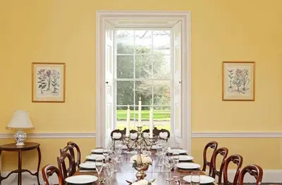 a dining room with a long table and a window at Bressingham Hall in Bressingham