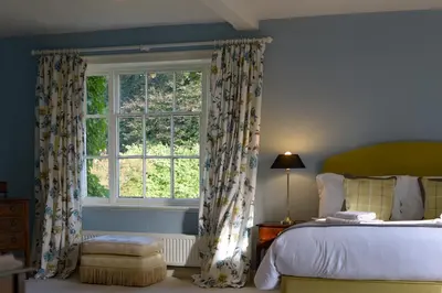 a bedroom with a bed and a large window at Bressingham Hall in Bressingham
