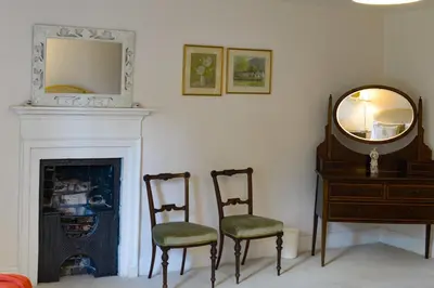 a living room with two chairs and a mirror at Bressingham Hall in Bressingham