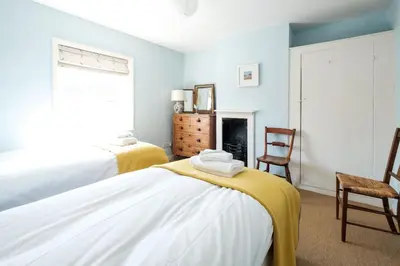 a bedroom with two beds and a fireplace at 201 High Street in Aldeburgh