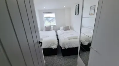 a small room with two beds and a mirror at ED Colchester Accommodation with Garden View in Colchester