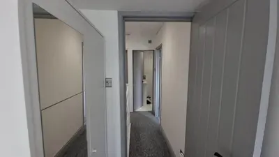 an empty hallway with a hallway leading to a bathroom at ED Colchester Accommodation with Garden View in Colchester