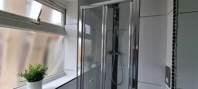 a shower in a bathroom next to a window at ED Colchester Accommodation with Garden View in Colchester