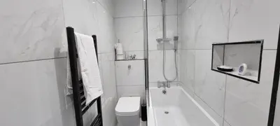 a white bathroom with a tub and a toilet at ED Colchester Accommodation with Garden View in Colchester