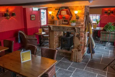 a room with a fireplace and a table in a restaurant at Old Station Apartments in Cambridge