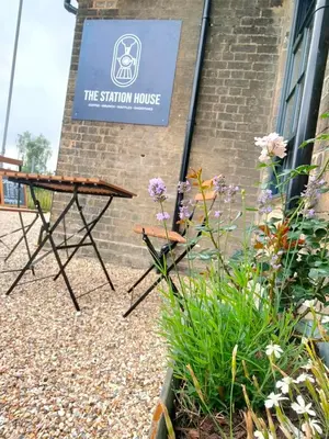 a sign for the station house with a table and flowers at Old Station Apartments in Cambridge