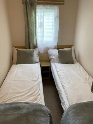 two beds in a small room with a window at 5 mins walk to beach. 3 bedroom caravan. Sleeps 8 in Clacton-on-Sea
