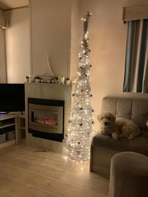 a christmas tree in a living room with a teddy bear at 5 mins walk to beach. 3 bedroom caravan. Sleeps 8 in Clacton-on-Sea
